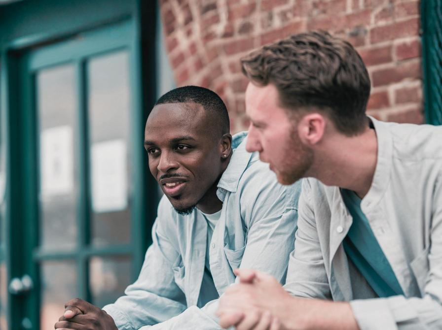 Foto af to mænd, der taler sammen udenfor